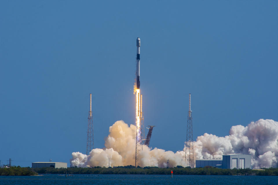 A SpaceX Falcon 9 rocket rises into the skies of Florida, with exhaust billowing around it.