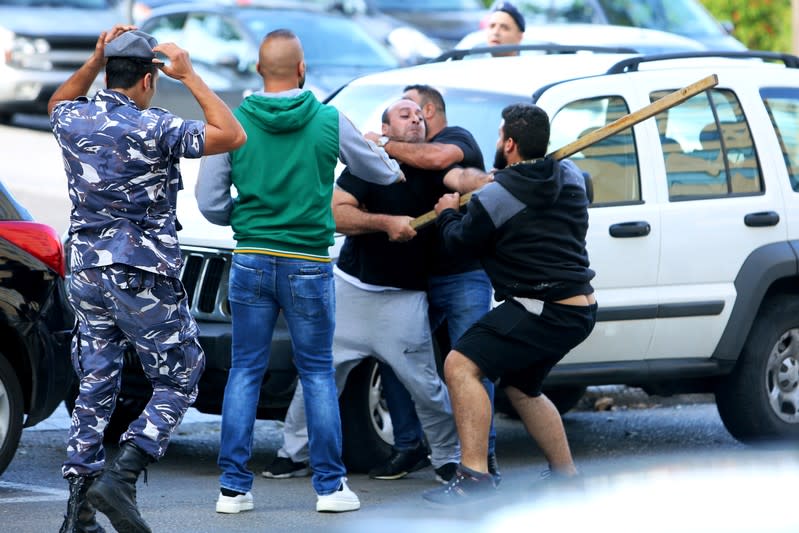 Supporters of Lebanese Shi'ite groups Hezbollah and Amal scuffle with protesters at a roadblock on a main road in Beirut, during ongoing anti-government protest