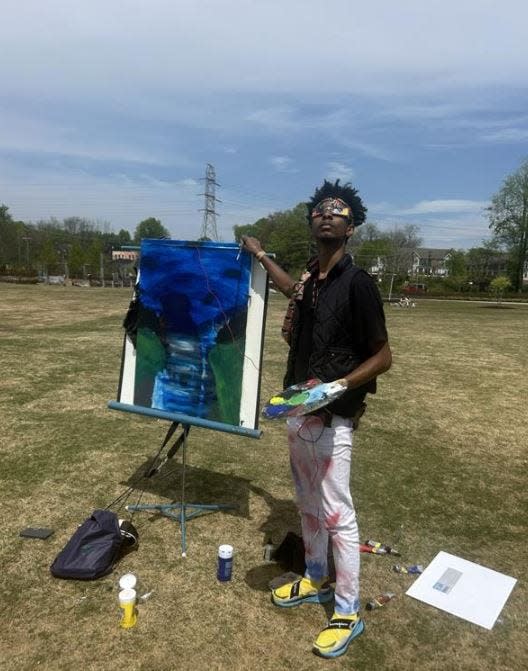Raamen Stallings was painting in Unity Park to celebrate and commemorate the solar eclipse.