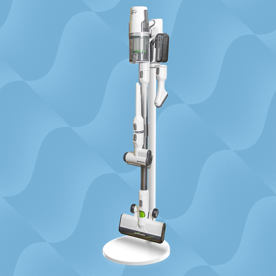 the greenworks cordless stick vacuum against a wave blue background