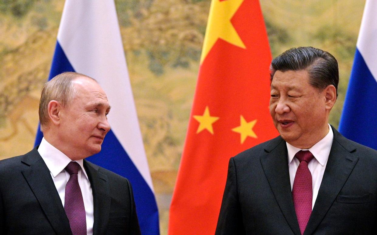 FILE - Chinese President Xi Jinping, right, and Russian President Vladimir Putin talk to each other during their meeting in Beijing, China on Feb. 4, 2022. Just weeks before the Feb. 24, 2022, invasion, Xi hosted Putin in Beijing for the opening of the Winter Olympics, at which time the sides issued a joint statement pledging their commitment to a "no limits" friendship. China has since ignored Western criticism and reaffirmed that pledge, underscoring how the two countries have aligned their foreign policies to oppose the liberal international world order led by the United States and its democratic allies. (Alexei Druzhinin, Sputnik, Kremlin Pool Photo via AP, File) - Alexei Druzhinin/Sputnik/AP