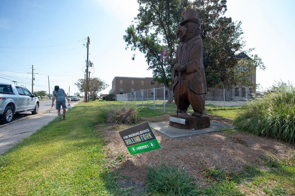 Rolling Fork resident John Abney sprays weeds along the sidewalk near the carved wooden bear on the corner of Walnut and Locus Streets near the Sharkey County Courthouse Thursday, Sept. 21.