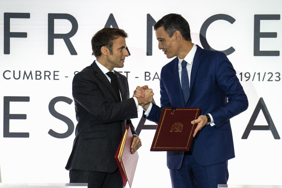 French President Emmanuel Macron, left, shakes hand with Spanish counterpart Pedro Sánchez in Barcelona, Spain, on Thursday, Jan. 19, 2023. A summit between the Spanish and French governments, led by their executive leaders, prime minister Pedro Sánchez and president Emmanuel Macron, is held in the capital of Catalonia to strengthen relations between the European neighbors by signing a friendship treaty. (AP Photo/Emilio Morenatti)