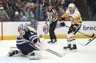 Columbus Blue Jackets goalie Elvis Merzlikins, left, makes a stop in front of Pittsburgh Penguins forward Reilly Smith during the first period of an NHL hockey game in Columbus, Ohio, Saturday, March 30, 2024. (AP Photo/Paul Vernon)