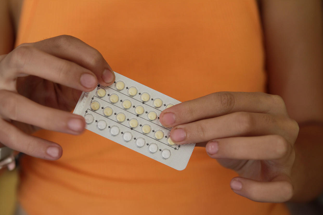 Woman holding birth control pills Getty Images/Isabel Pavia