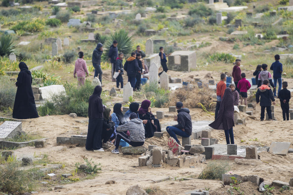 Palestinians visit the graves of their relatives who were killed in the war between Israel and the Hamas militant group on the first day of the Muslim holiday of Eid al-Fitr, in Deir al-Balah, Gaza, Wednesday, April 10, 2024. (AP Photo/Abdel Kareem Hana)