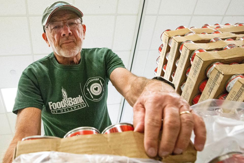 Phil Williamson, a volunteer for 12 years at the Food Bank of Delaware, organizes canned goods in the volunteer room at the Food Bank in Milford, Thursday, Nov. 9, 2023.