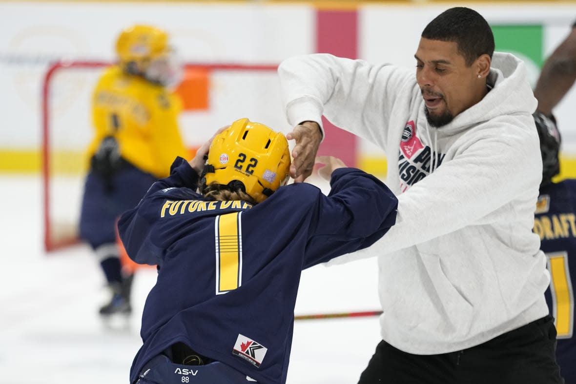 Minnesota Wild hockey player Ryan Reaves, right, pretends to fight with Hayden Spalin during a youth hockey clinic with NHL top draft prospects and members of the NHL Player Inclusion Coalition, Tuesday, June 27, 2023, in Nashville, Tenn. (AP Photo/George Walker IV)