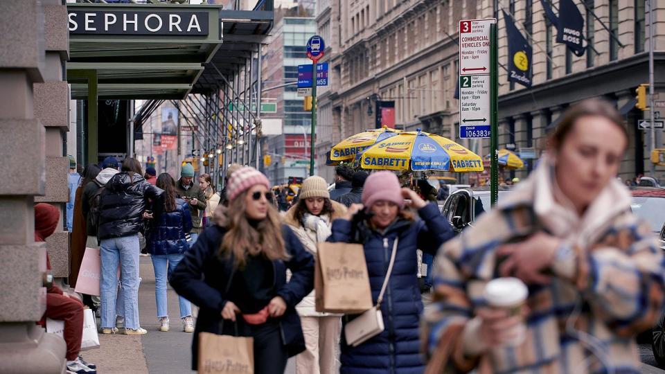 Mujeres caminando por la puerta de una tienda Sephora.