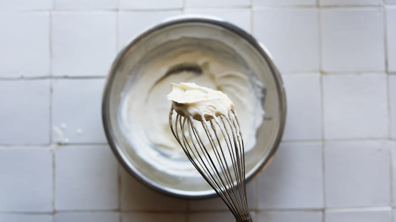 Crème fraîche whipped cream in bowl with whisk