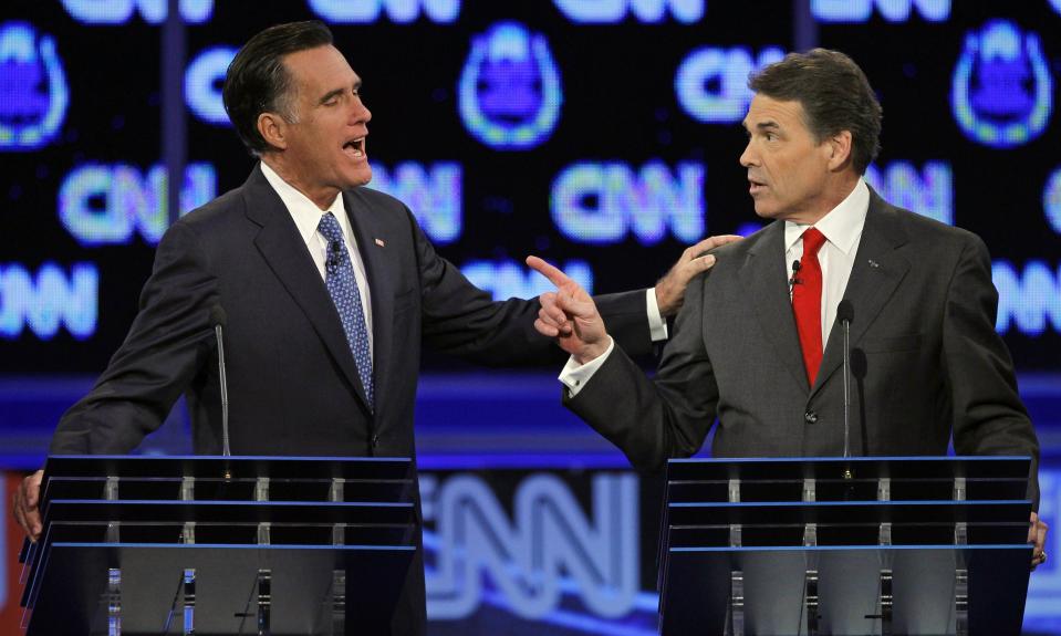 In this Oct. 18, 2011, file photo Republican presidential candidates, former Massachusetts Gov. Mitt Romney, left, and Texas Gov. Rick Perry, talk during a Republican presidential debate in Las Vegas. | Chris Carlson, Associated Press