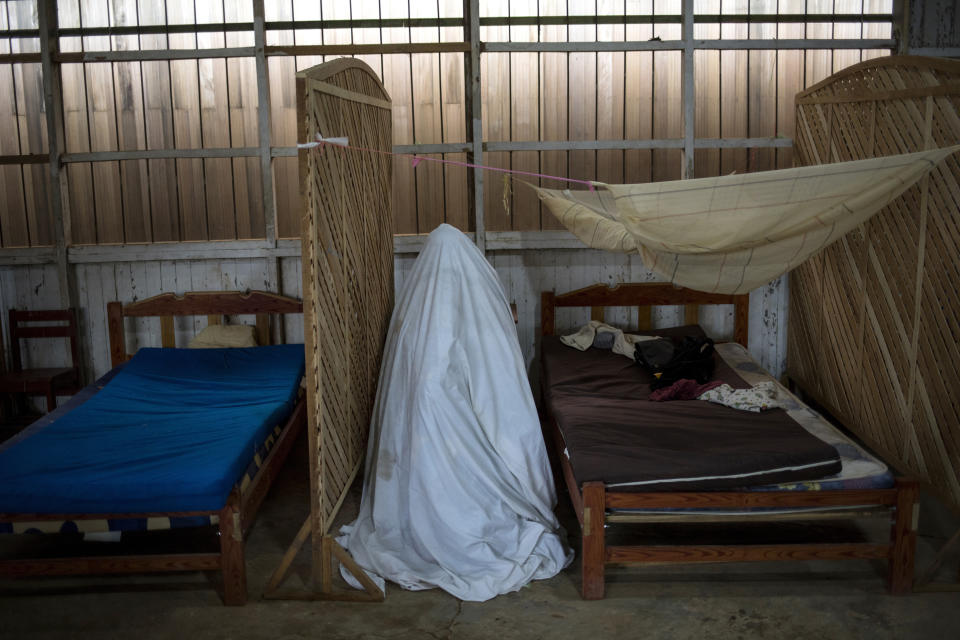 Sara Magin, quien tiene síntomas de COVID-19, sentada en el interior de una tienda de campismo construida con una sábana mientras recibe una terapia de vapores herbales, en la sede del Comando Matico, en la comunidad indígena Shipibo de Pucallpa, en la región peruana de Ucayali, el 1 de septiembre de 2020. Voluntarios han levantado un centro de tratamiento improvisado que trata el coronavirus con un enfoque holístico. (AP Foto/Rodrigo Abd)