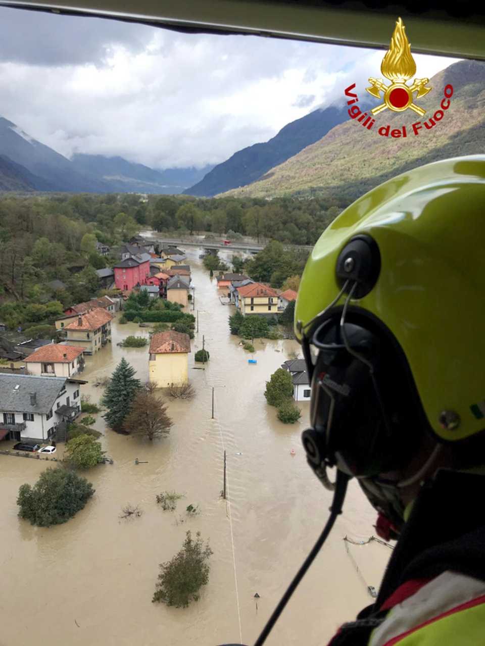 In this image made available Sunday, Oct. 4, 2020, firefighters fly over flooding in the town of Ornavasso, in the northern Italian region of Piedmont. (Firefighter Vigili del Fuoco via AP)