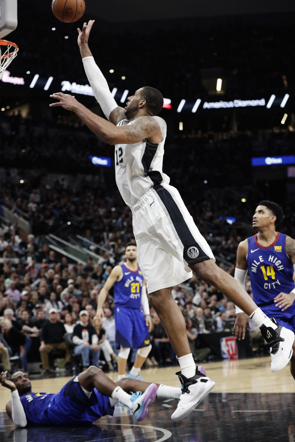 San Antonio Spurs center LaMarcus Aldridge (12) shoots over Denver Nuggets forward Paul Millsap, on court, during the first half of Game 3 of an NBA basketball playoff series in San Antonio, Thursday, April 18, 2019. San Antonio won 118-108. (AP Photo/Eric Gay)