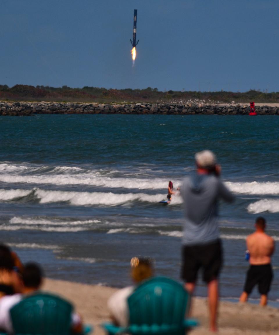Spectators  on the beach in Cape Canaveral watch the booster landing at Landing Zone 1 at Cape Canaveral Space Force Station. SpaceX Falcon 9 rocket launched from Pad 40 at Cape Canaveral Space Force Station Thursday, March 9 at 2:13 p.m. EST. 