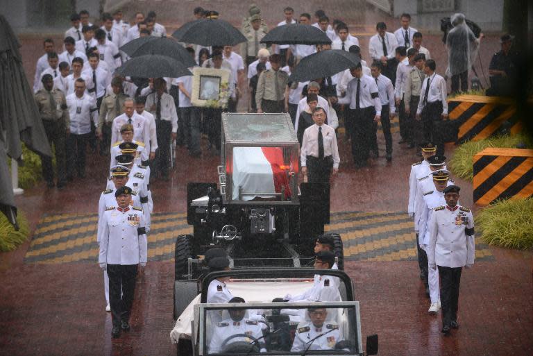 The body of Singapore&#39;s former prime minister Lee Kuan Yew is transferred atop a gun carriage as they leave Parliament House during a funeral procession in Singapore on March 29, 2015