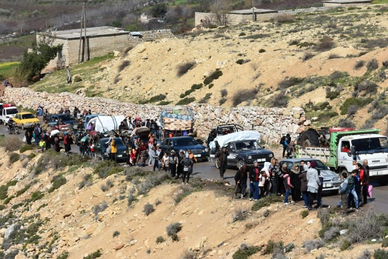 Civilians flee the city of Afrin in northern Syria along a mountain road in the government-controlled part of the northern Aleppo province, on March 16, 2018