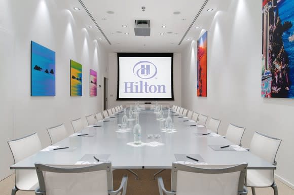 Meeting room with the Hilton logo projected onto the screen at the front.