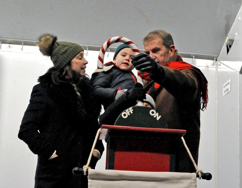 Chris and Steve Matthews, with help from grandchildren Dean Spittle and Arianna Salazar pull the candy cane switch to light the Christmas tree Friday during Window Wonderland in downtown Wooster.