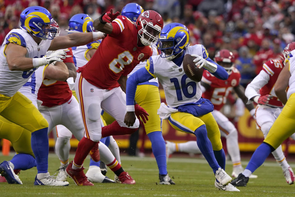 Los Angeles Rams quarterback Bryce Perkins (16) runs from Kansas City Chiefs defensive end Carlos Dunlap (8) during the first half of an NFL football game Sunday, Nov. 27, 2022, in Kansas City, Mo. (AP Photo/Ed Zurga)