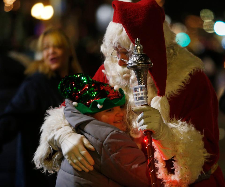 Willie Melton III gives a hug to Santa Claus, Bill Tomkins of the Amerscot Highland Pipe Band during the Celebration of Lights Parade in the City of Poughkeepsie in 2018.