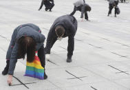 People paint black crosses for the victims of the COVID-19 pandemic in Pilsudski Square, Warsaw, Poland, Saturday, April 10, 2021. Almost 56,000 people have died of COVID-19 in this nation of around 38 million. (AP Photo/Czarek Sokolowski)