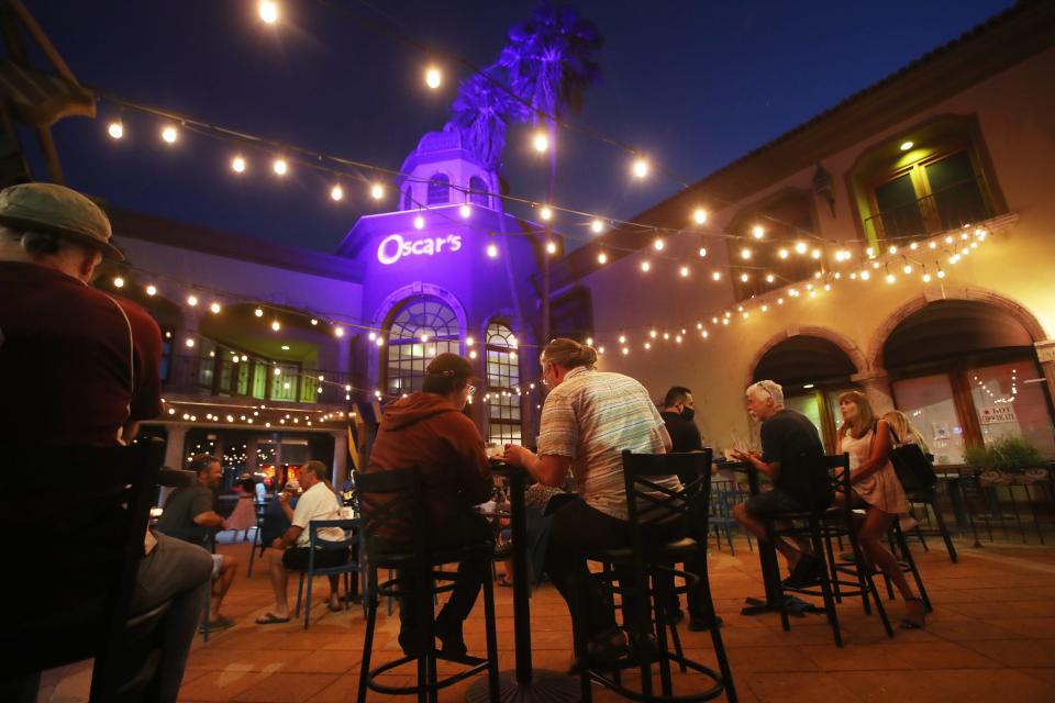Patrons sit under strings of lights in the outdoor courtyard of Oscar's in downtown Palm Springs, Calif., on May 13, 2021. Oscar's will be holding its first T Dance since the pandemic this Sunday. The event for prescreened, fully-vaccinated attendees is sold-out. 