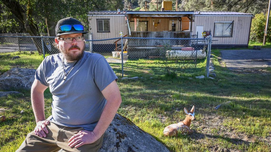 Lifelong El Portal Trailer Park resident Luke Harbin sits in the front yard of his mother’s mobile home before getting ready to move out for good on Sunday, March 13, 2022.
