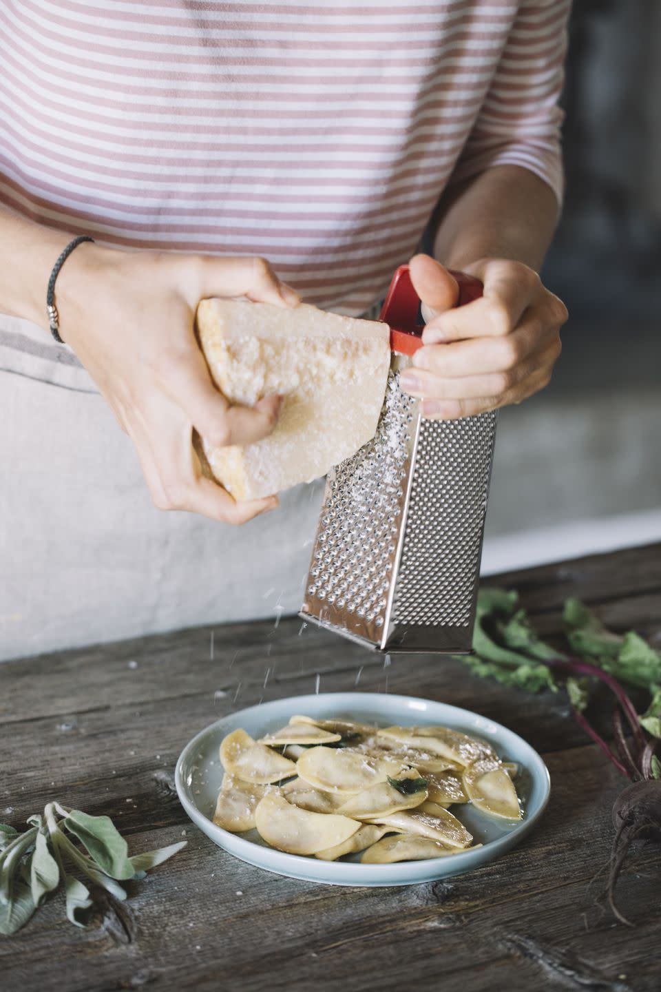 filled ravioli on plate, cheese grater