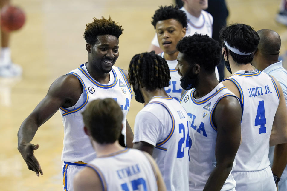 UCLA forward Kenneth Nwuba, left, celebrates with teammates after a 91-61 win over Washington State in an NCAA college basketball game Thursday, Jan. 14, 2021, in Los Angeles. (AP Photo/Ashley Landis)