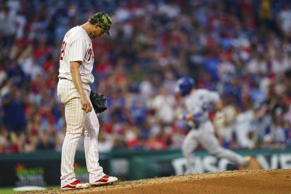 Phillies starter Aaron Nola looks down as the Dodgers' Will Smith, back right, rounds the bases after homering May 21, 2022.