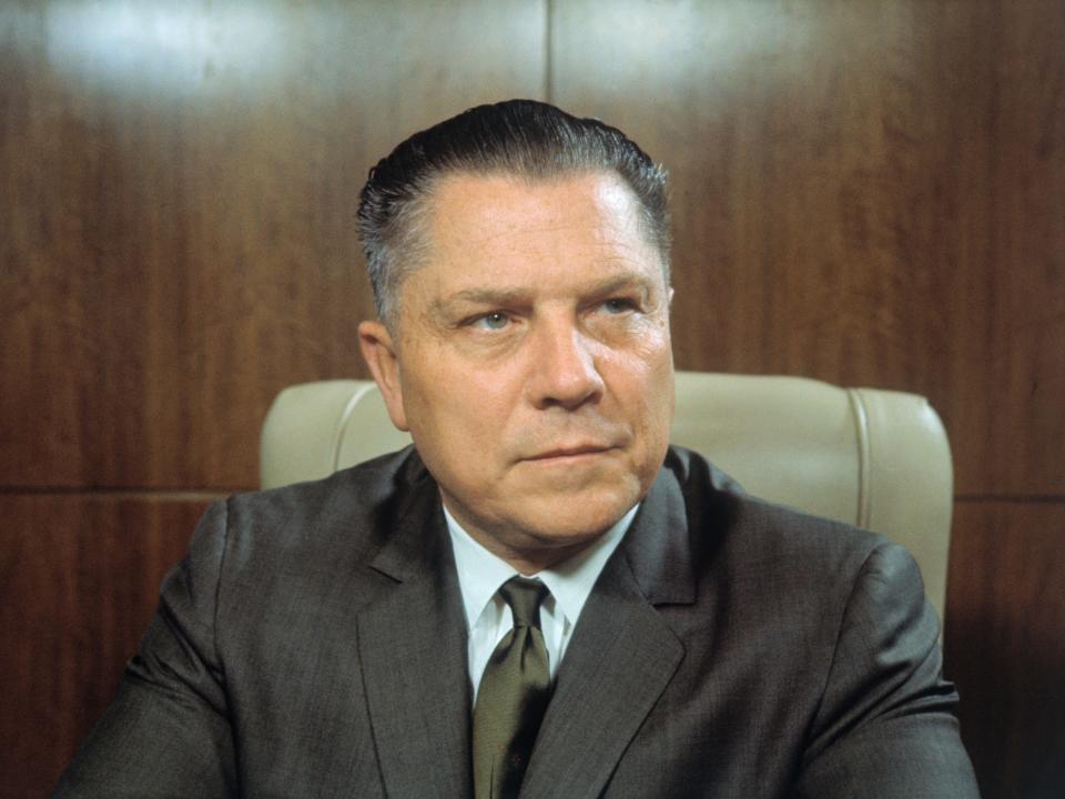 Jimmy Hoffa sits in a chair and looks to the side