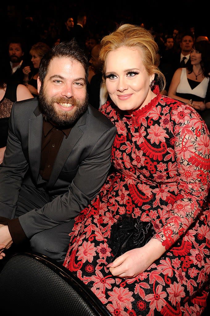 Simon in a dark suit and Adele in a floral dress, sitting together at an event