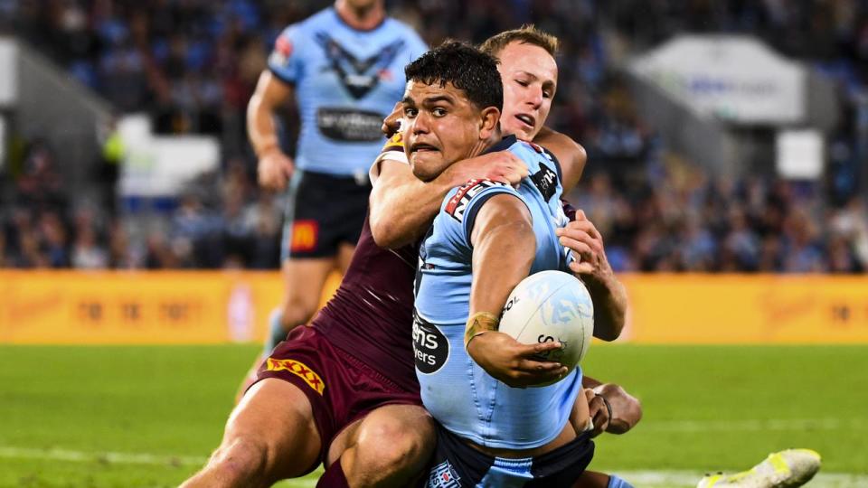 Latrell Mitchell of the Blues is tackled by Daly Cherry-Evans.