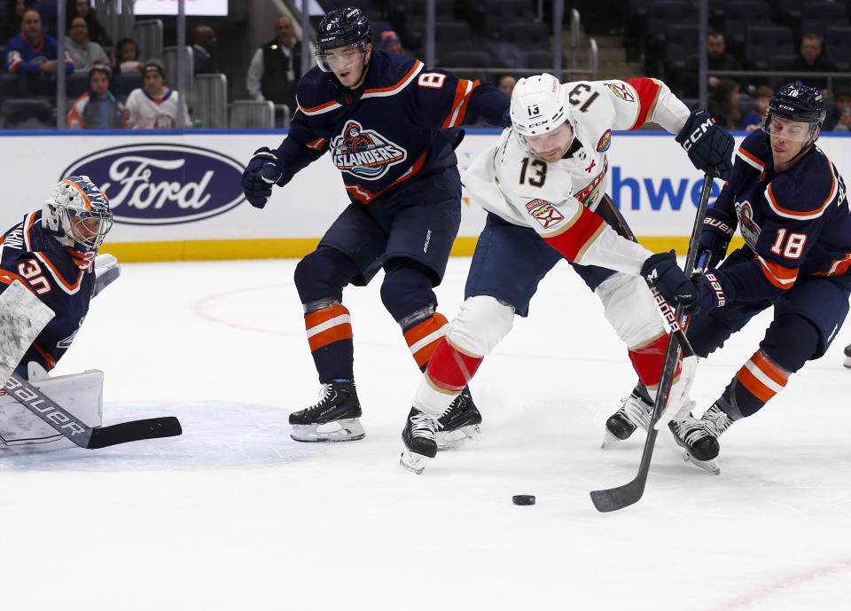 Florida Panthers center Sam Reinhart (13) controls the puck between New York Islanders goalie Ilya Sorokin, left, defenseman Noah Dobson (8) and forward Anthony Beauvillier (18) during the first period of an NHL hockey game Friday, Dec. 23, 2022, in Elmont, N.Y. (AP Photo/John Munson)