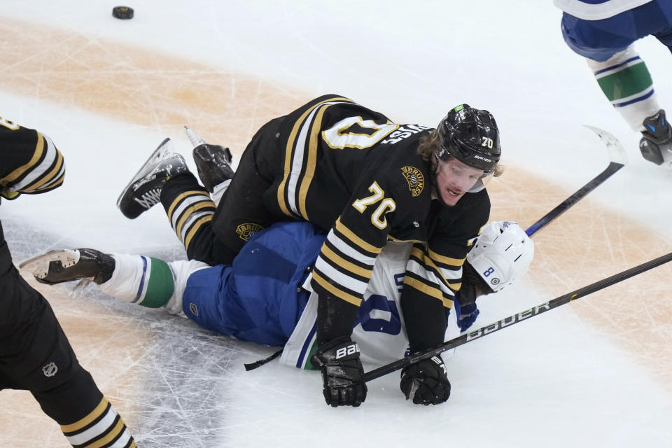 Boston Bruins center Jesper Boqvist (70) and Vancouver Canucks right wing Conor Garland (8) tumble after colliding during the second period of an NHL hockey game Thursday, Feb. 8, 2024, in Boston. (AP Photo/Steven Senne)