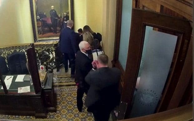 Mike Pence looks back as he is rushed out of a secure room and evacuated from the US Capitol  - US Senate/Reuters