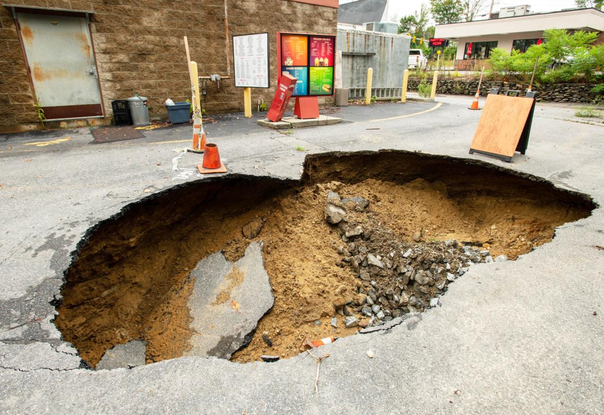 A sinkhole is seen behind Dippin’ Donuts in North Leominster after flash floods hit the area in September.