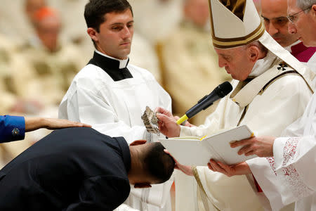 Pope Francis baptizes a faithful during the Easter vigil Mass in Saint Peter's Basilica at the Vatican, April 20, 2019. REUTERS/Remo Casilli