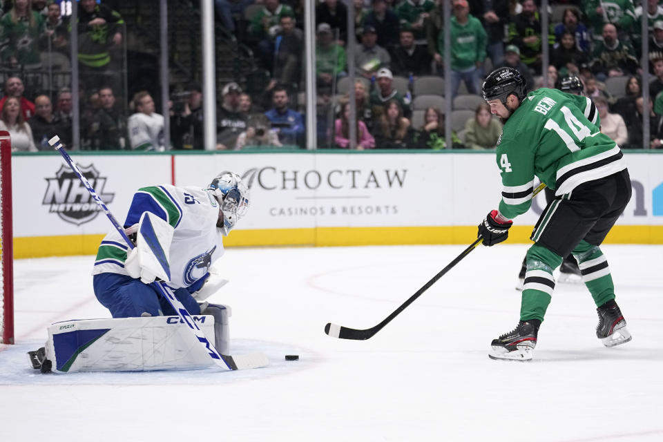 Dallas Stars left wing Jamie Benn (14) prepares to shoot and score against Vancouver Canucks goaltender Thatcher Demko, left, in the first period of an NHL hockey game, Monday, Feb. 27, 2023, in Dallas. (AP Photo/Tony Gutierrez)