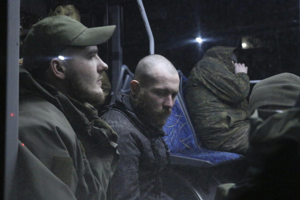 Ukrainian servicemen sit in a bus after leaving Mariupol's besieged Azovstal steel plant, near a penal colony, in Olyonivka, in territory under the government of the Donetsk People's Republic, eastern Ukraine, Friday, May 20, 2022. (AP Photo)