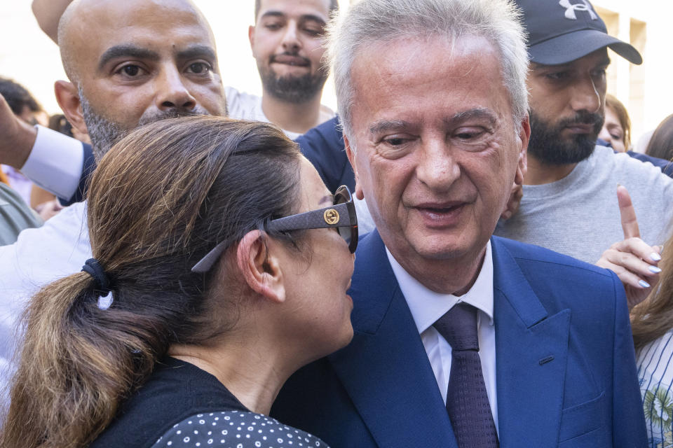 Riad Salameh, right, Lebanon's outgoing Central Bank governor, greets employees at a farewell ceremony marking the end of his 30 years in office outside the Central Bank building, in Beirut, Monday, July 31, 2023. Meanwhile, his four vice governors, led by incoming interim governor Wassim Mansouri, urged the cash-strapped country's government for fiscal reforms at a news conference in that same building. (AP Photo/Hassan Ammar)