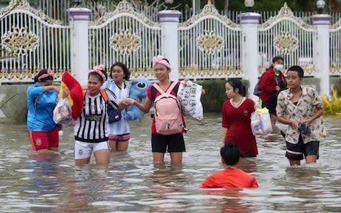 People wade through floodwaters from Tropical Storm Pabuk, Friday, Jan. 4, 2019, in Pak Phanang, in the southern province of Nakhon Si Thammarat - Credit: &nbsp;Thanis Sudto/AP