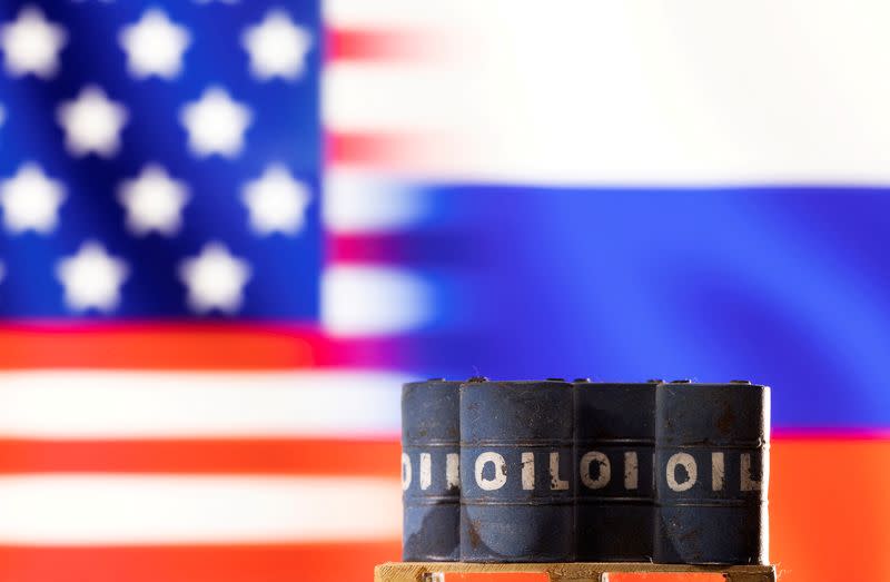 FILE PHOTO: Illustration shows Models of oil barrels in front of sign U.S. and Russia flag colours