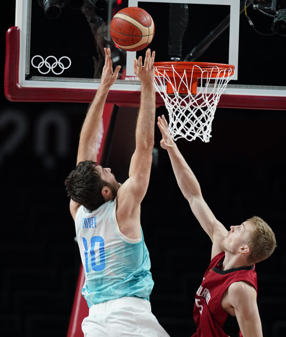 Slovenia's Mike Tobey (10), left, shoots over Germany, right, during men's basketball quarterfinal game at the 2020 Summer Olympics, Tuesday, Aug. 3, 2021, in Saitama, Japan. (AP Photo/Charlie Neibergall)