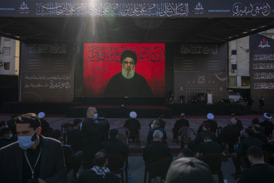 Hezbollah supporters listen to their leader Sayyed Hassan Nasrallah as he speaks via a video link during Ashoura, the Shiite Muslim commemoration marking the death of Immam Hussein, the grandson of the Prophet Muhammad, at the Battle of Karbala in present-day Iraq in the 7th century, in southern Beirut, Lebanon, Thursday, Aug. 19, 2021. The leader of the militant Hezbollah group Sayyed Hassan Nasrallah said Thursday that the first Iranian fuel tanker will sail toward Lebanon "within hours" warning Israel and the United States not to intercept it. (AP Photo/ Hassan Ammar)