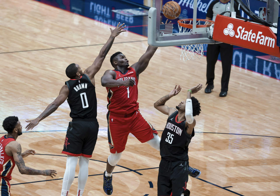New Orleans Pelicans forward Zion Williamson (1) shoots between Houston Rockets guard Sterling Brown (0) and center Christian Wood (35) during the fourth quarter of an NBA basketball game in New Orleans, Saturday, Jan. 30, 2021. (AP Photo/Derick Hingle)