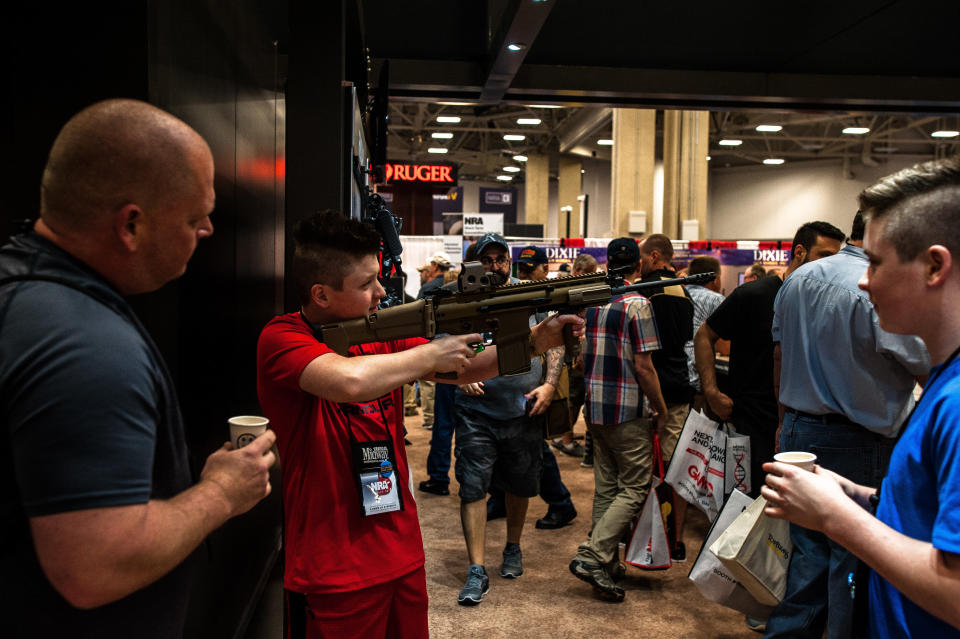 A local Dallas family passes around a rifle on the expo floor Friday.