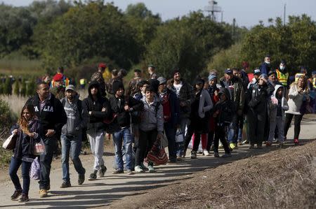 Migrants queue to board a train at the railway station in Zakany, Hungary October 1, 2015. REUTERS/Bernadett Szabo