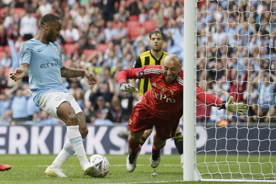 Manchester City's Raheem Sterling, left, scores his side's sixth goal past Watford's goalkeeper Heurelho Gomes during the English FA Cup Final soccer match between Manchester City and Watford at Wembley stadium in London, Saturday, May 18, 2019. (AP Photo/Tim Ireland)